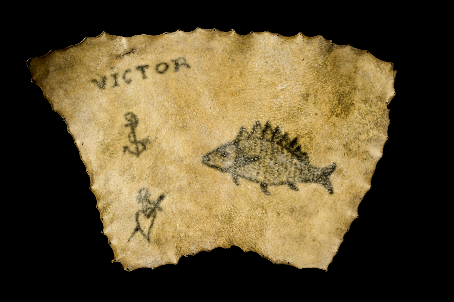 An anchor, pierced heart, fish and the inscription 'VICTOR' are tattooed onto human skin.