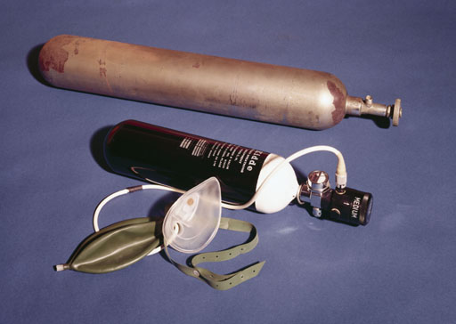 Oxygen cylinder from the British 1922 Everest Expedition, shown with a modern oxygen cylinder and breathing mask, similar to those used in the successful 1953 expedition.