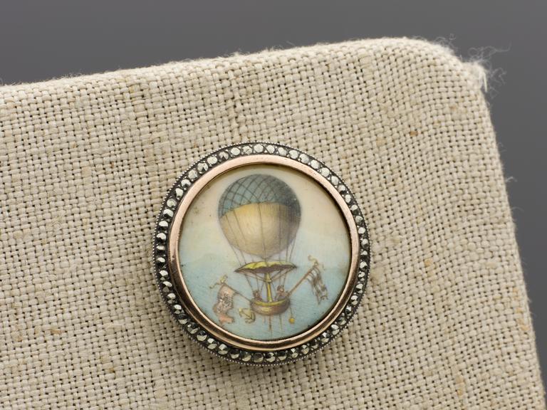 One of a set of six silver lined buttons painted with balloon scenes.