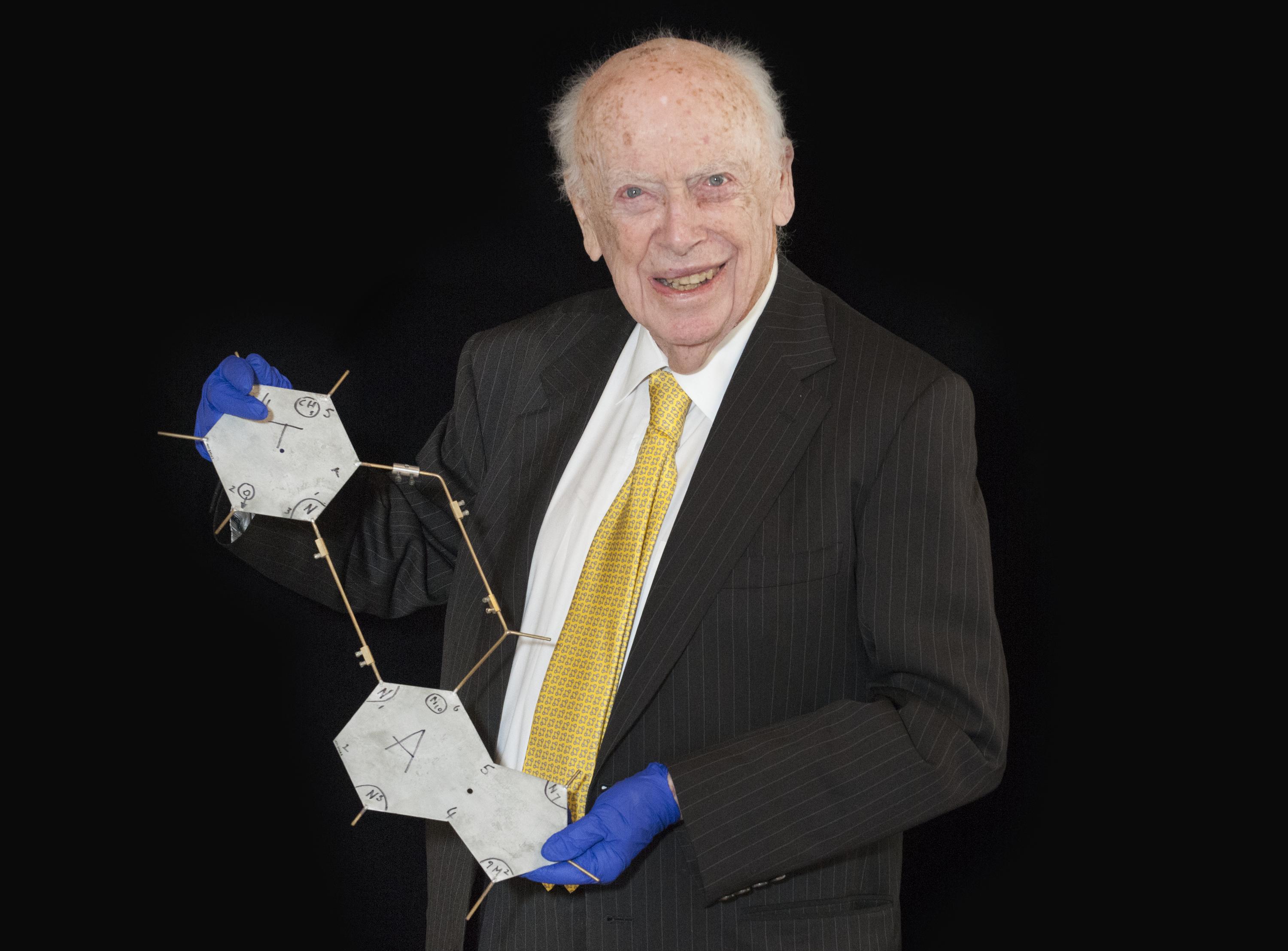 Portrait of James Watson, American molecular biologist, geneticist and zoologist, best known as one of the co-discoverers of the structure of DNA in 1953 with Francis Crick and Rosalind Franklin. Pictured with 1977-0300 metal plate representing the pyrimidines cytosine and thymine, and 18 metal plates representing the purines