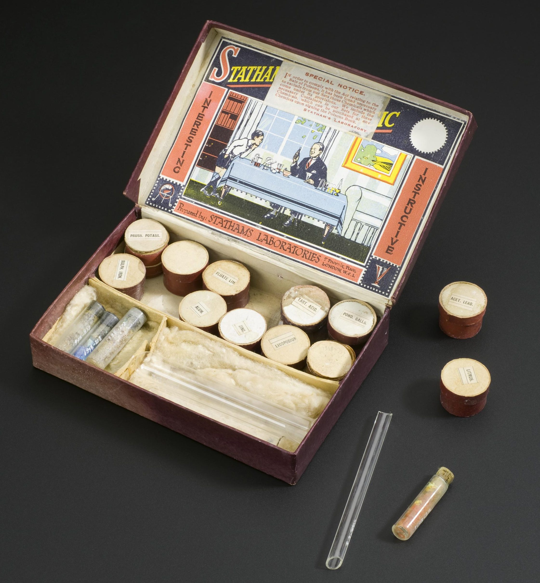 Stathams Chemical Magic chemistry set by Stathams Laboratories, London with instructions and cardboard case. Overhead view of whole object (open) against graduated grey background.