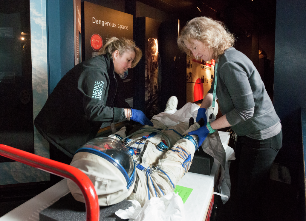 Geri Spencer, conservation assistant supervisor, and, conservation assistants, installing 2006-40/1 Helen Sharman's spacesuit which is being re-displayed in the Exploring Space gallery 