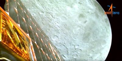 A photo of the moon's cratered surface and the side of Chandrayaan-3 spacecraft