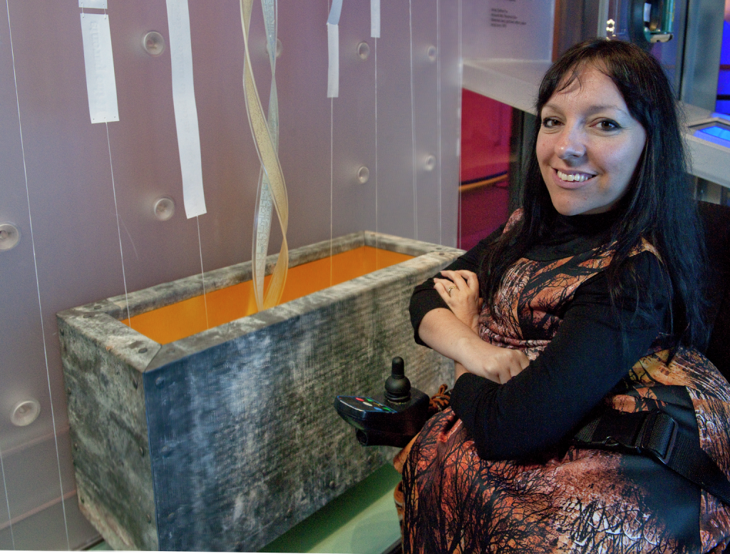 Artist Esther Fox pictured with her artwork in the Who Am I? gallery