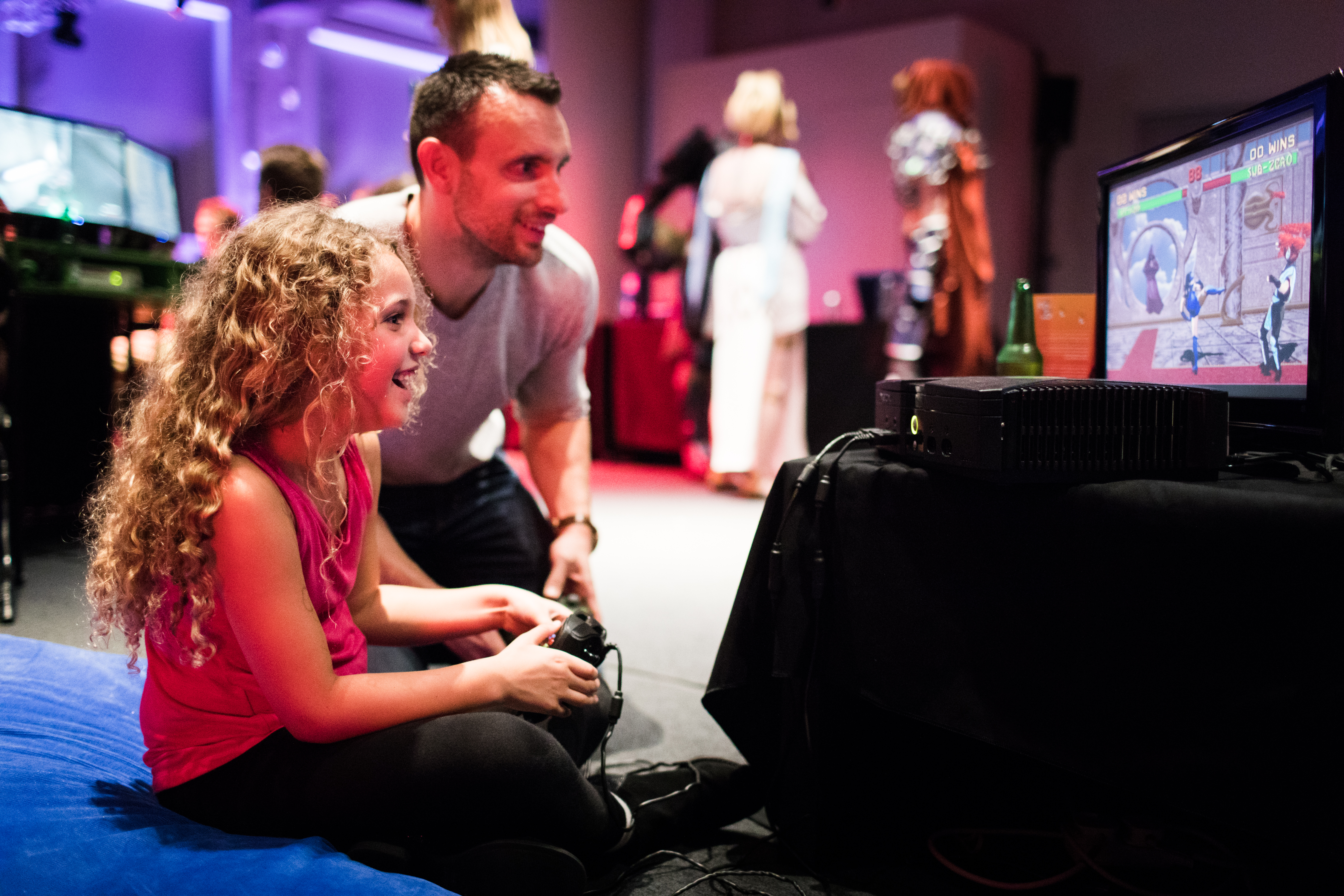 Young girl playing video game with her dad