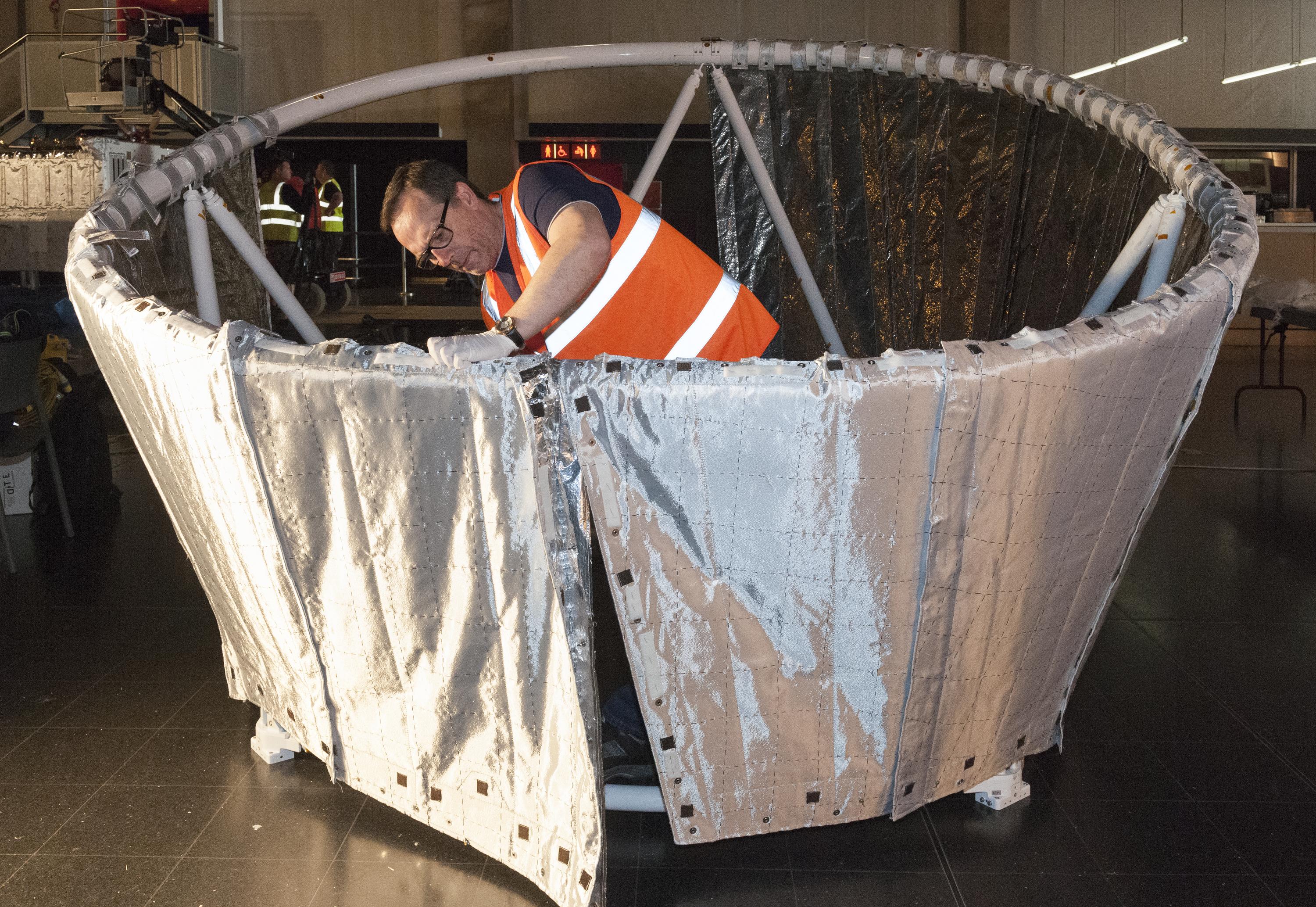 Engineers hand-stitching the space blanket onto the sun shield