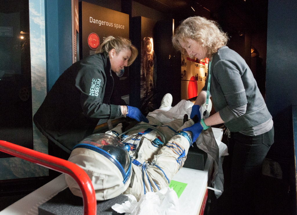 Geri Spencer, conservation assistant supervisor, and, conservation assistants, installing 2006-40/1 Helen Sharman's spacesuit which is being re-displayed in the Exploring Space gallery