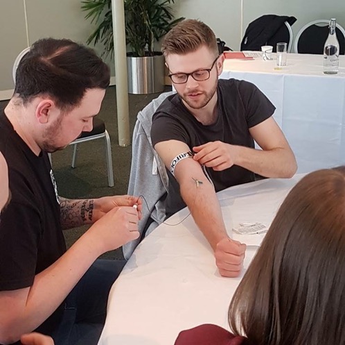 Luke letting a new haemophilia Dad practice injecting him (he hit the vein first time!) Credit: Luke Pembroke